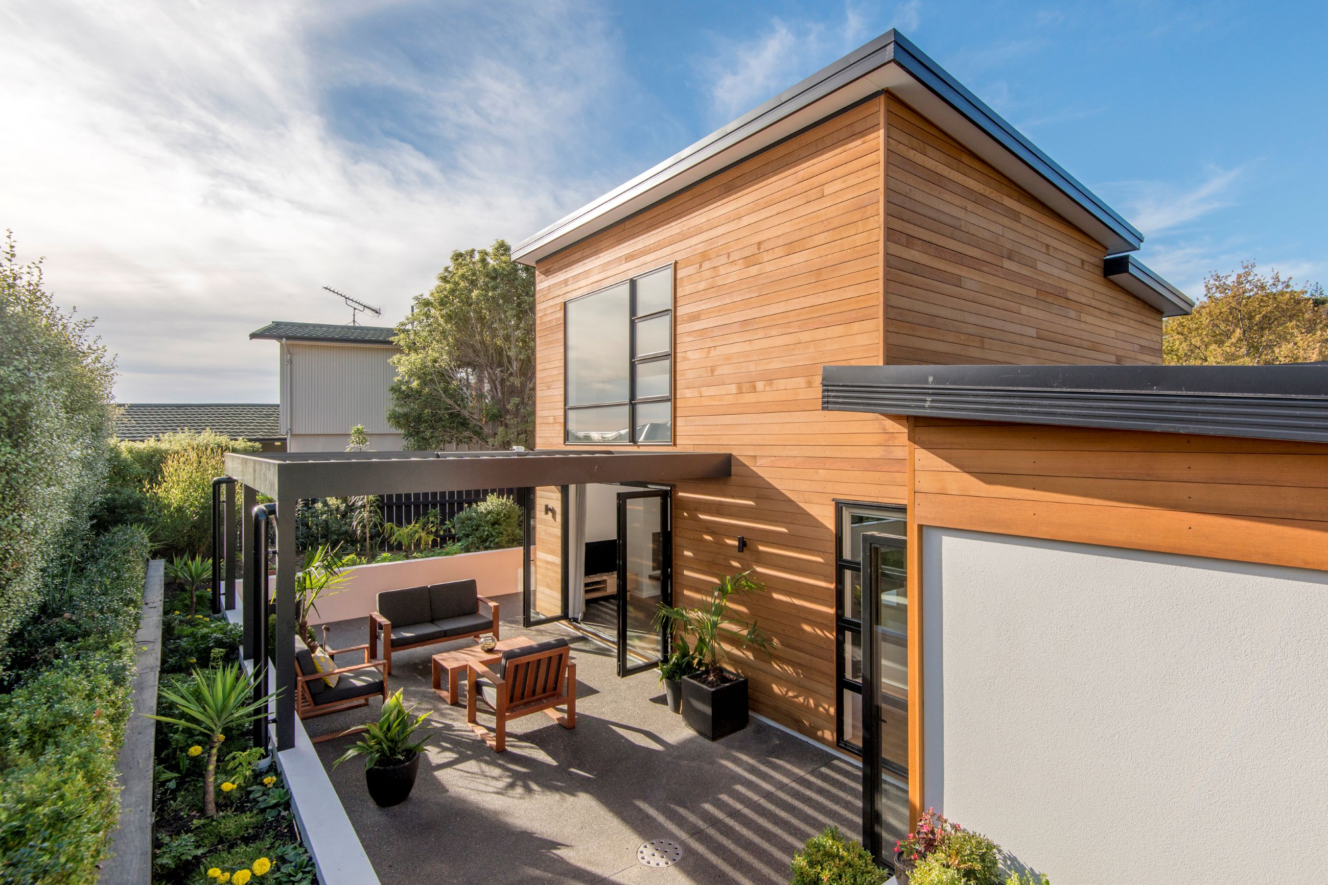 Mt-Pleasant-townhouse-courtyard-exposed-concrete-patio-louvre-roof-cedar-weatherboard-multi-level